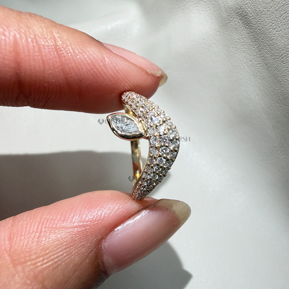 Holding solid gold asymmetrical wave ring displaying smooth comfort-fit interior and curved pavilion