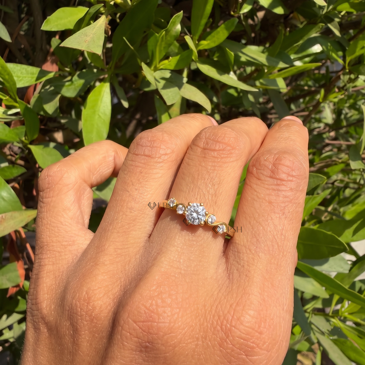 yellow gold wave diamond ring worn against natural garden greenery