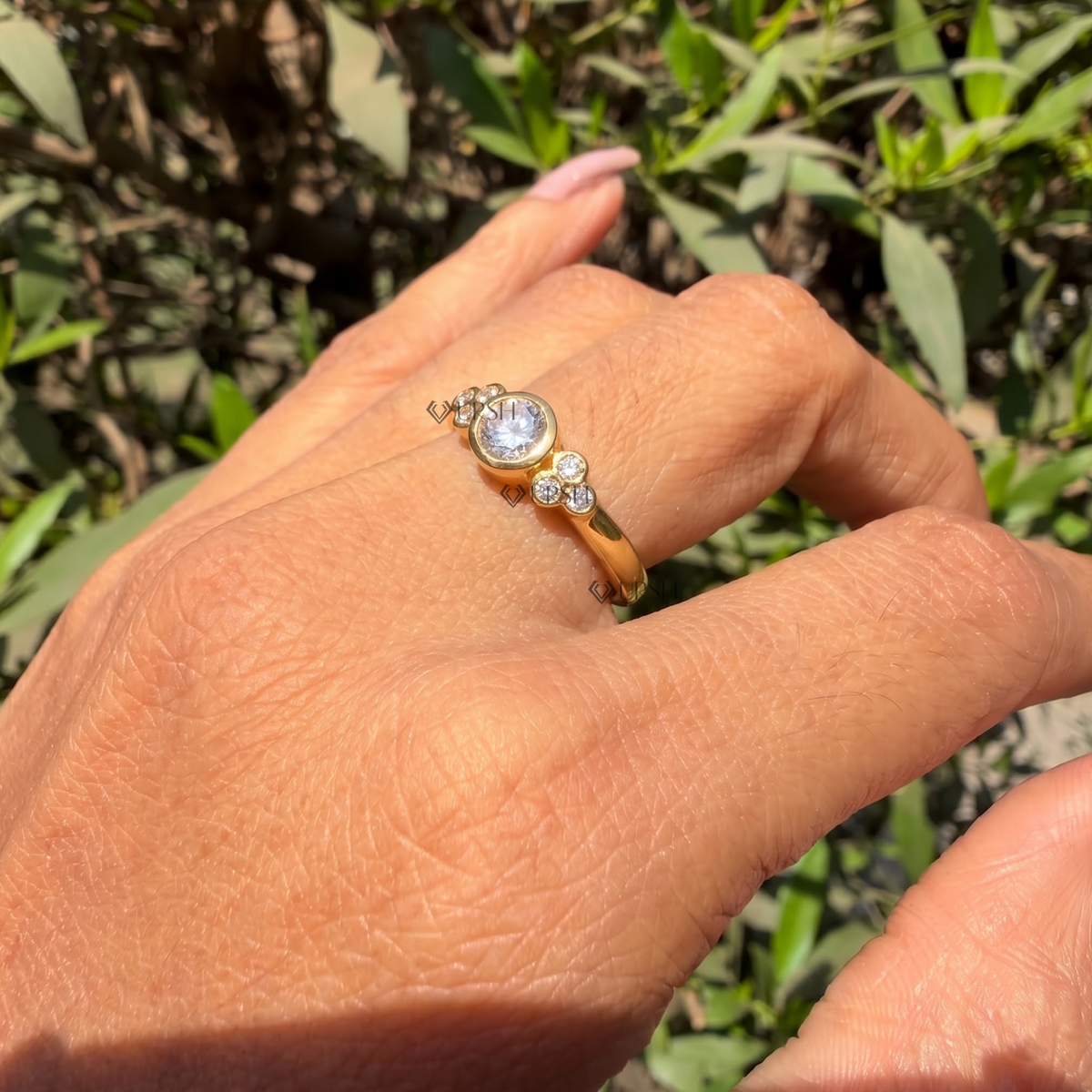 Daylight angle view of bezel cluster engagement ring worn on finger showcasing sleek profile