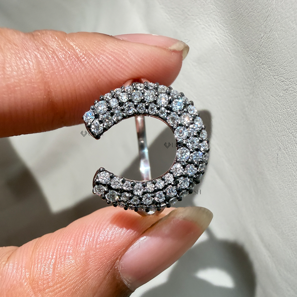 Close-up holding horseshoe cocktail ring highlighting dense pavé setting and comfortable inner band