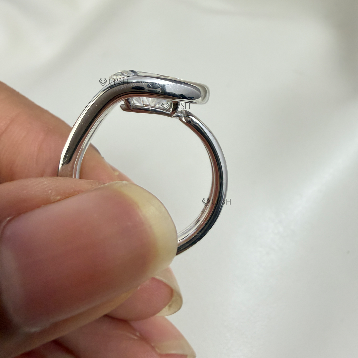 Profile view displaying floating diamond suspension and smooth polished inner band comfort fit