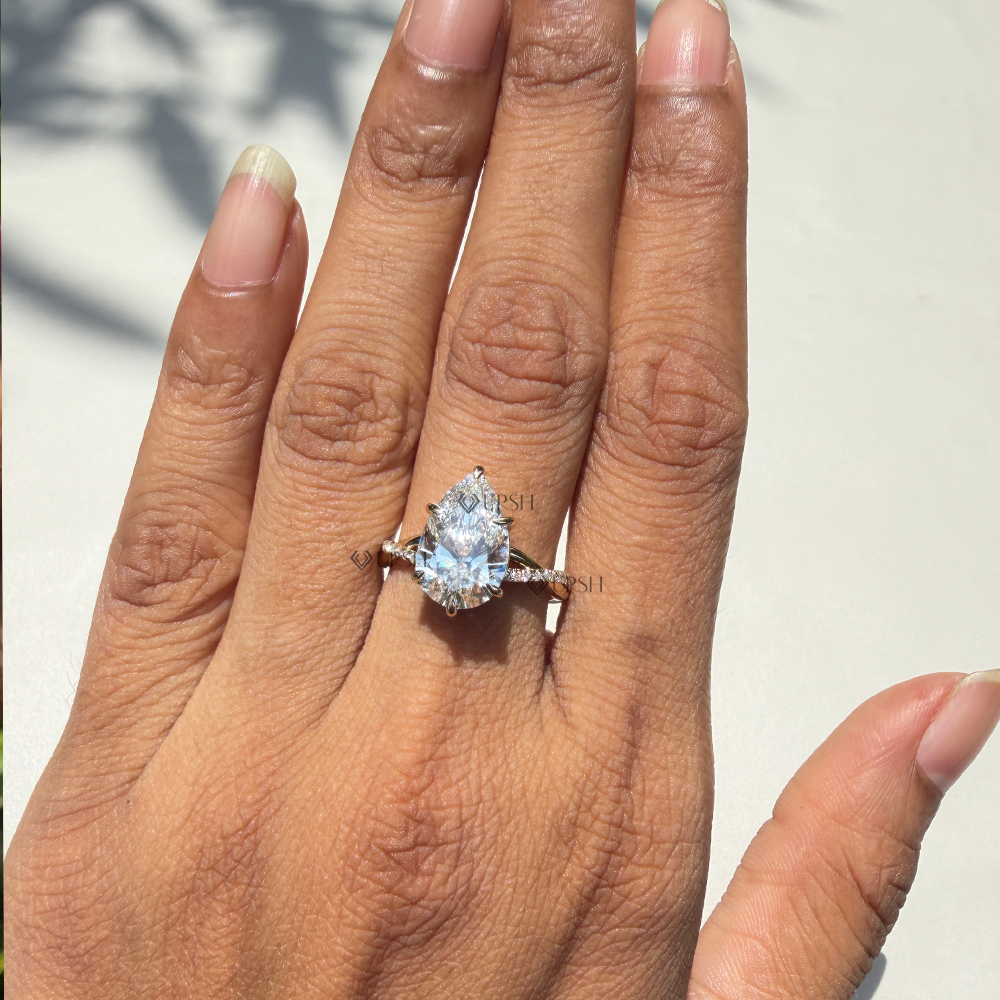 Pear cut lab diamond solitaire ring styled on ring finger in natural outdoor light