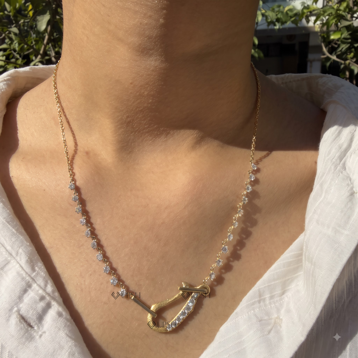 Daylight angle view of yellow gold carabiner lock diamond necklace worn against collarbone