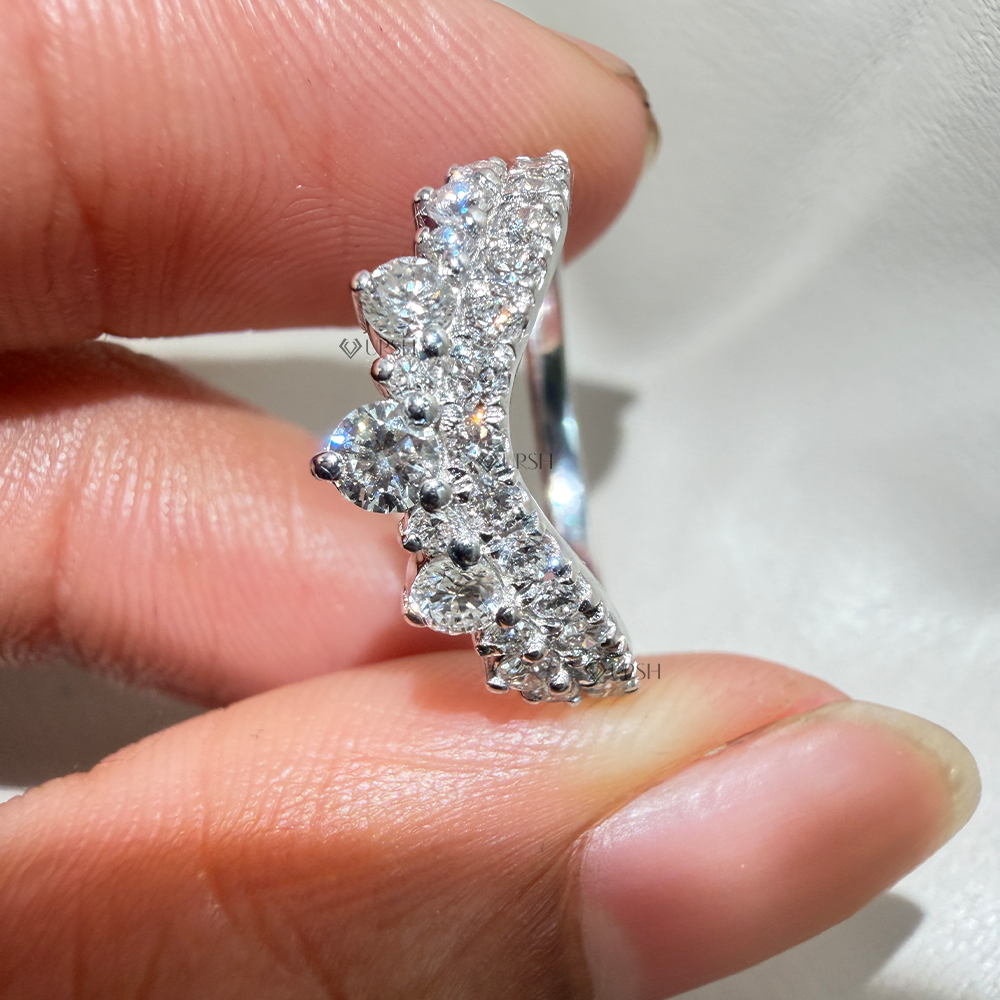 Close-up holding white gold contoured chevron crown band displaying dual pavé rows and peak stones