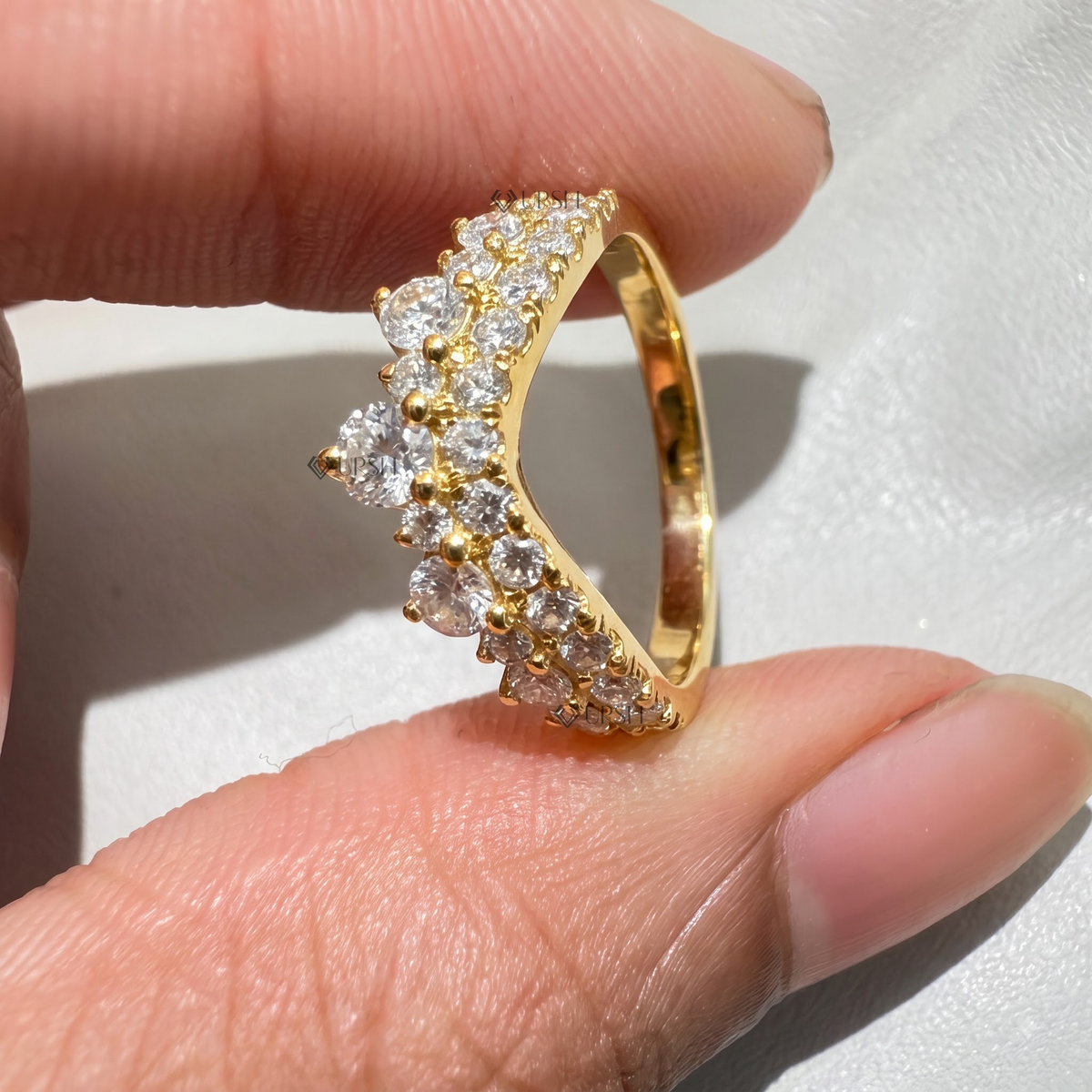 Holding yellow gold double-row chevron band displaying polished inner comfort-fit shank