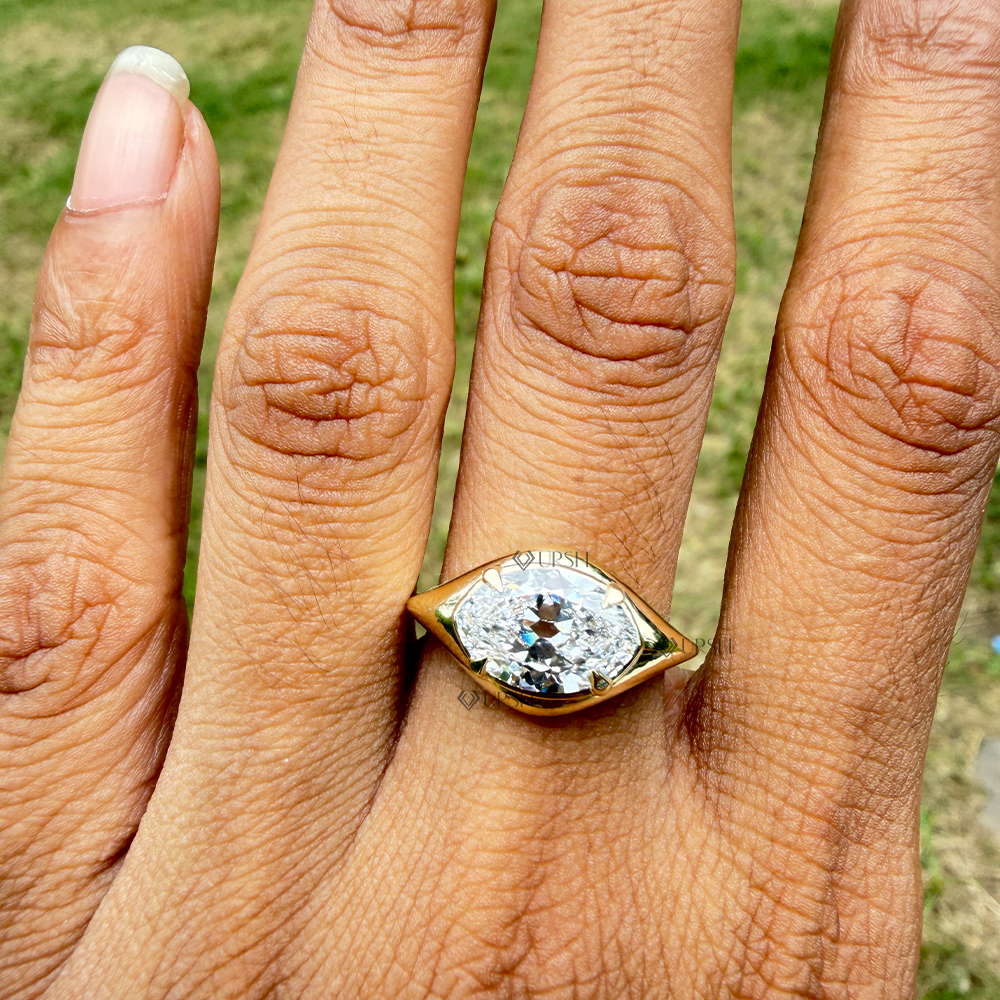 Horizontal marquise diamond gypsy bezel ring styled across finger in natural daylight