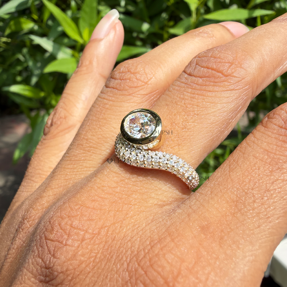 Asymmetrical east west oval diamond bezel wave ring worn on ring finger outdoors