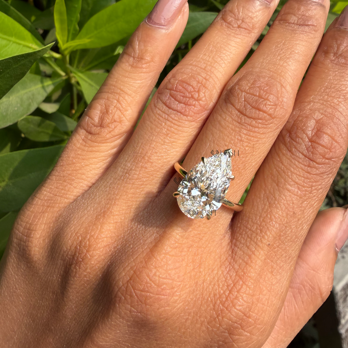 Oversized pear-cut diamond solitaire ring styled gracefully on finger in natural daylight