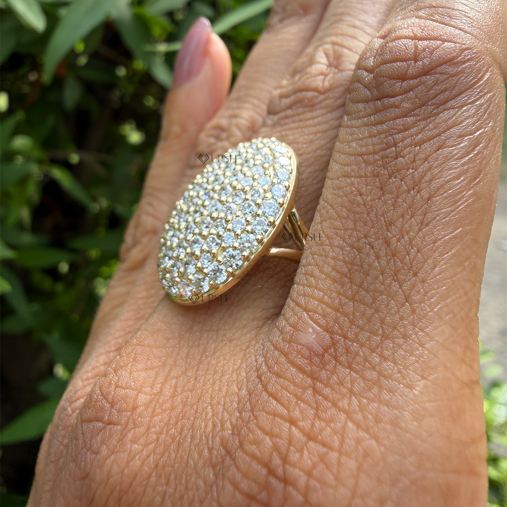 Side angle showing elevated curved oval disc silhouette and polished solid gold setting