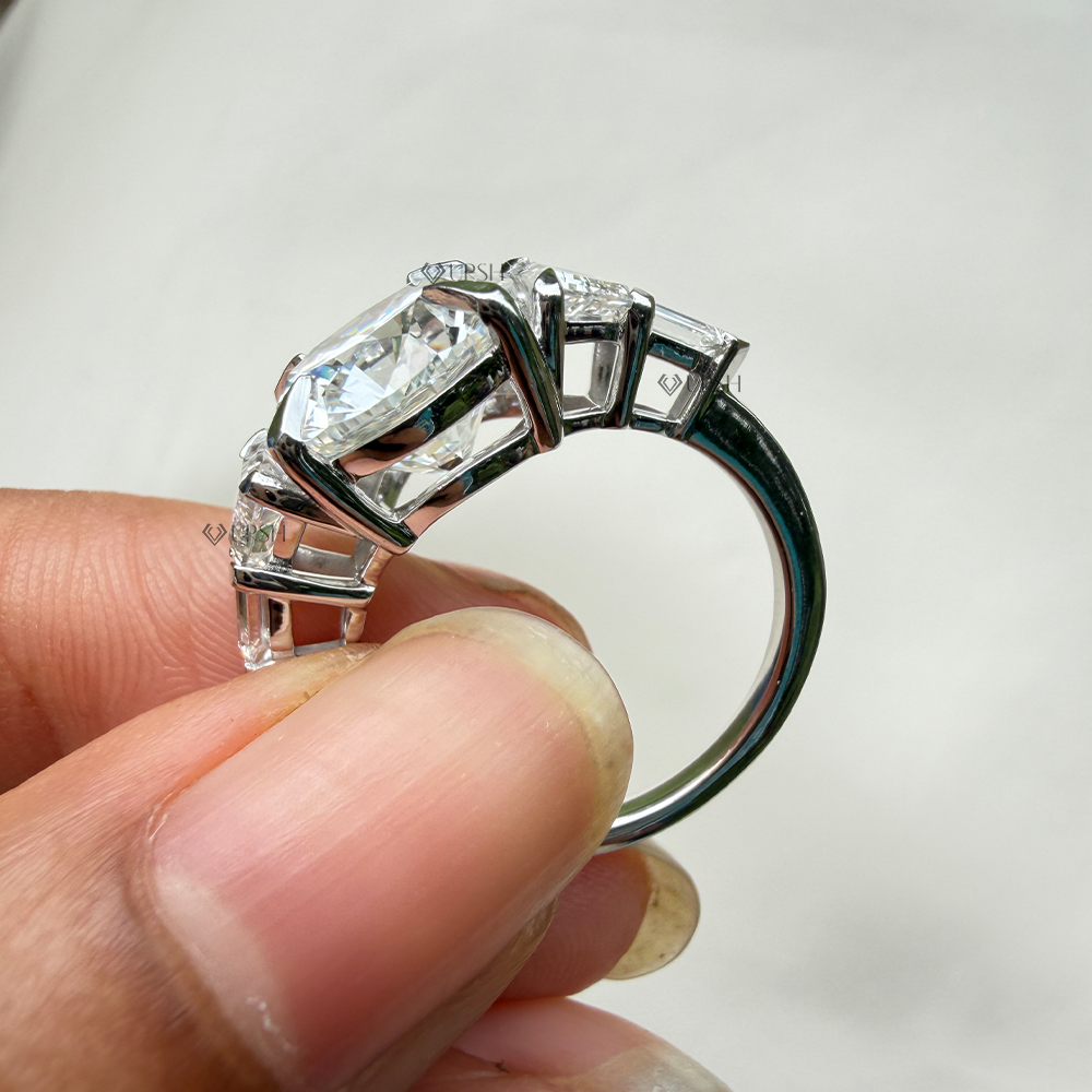 Side angle highlighting 6-prong center basket, stepped bullet and trapezoid side stones, and polished solid gold comfort shank