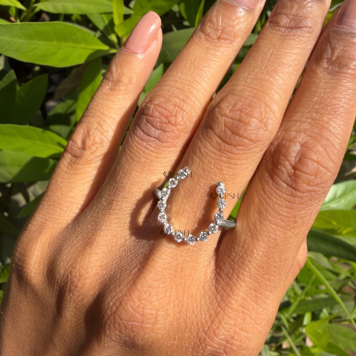 Curved open contour diamond ring highlighting negative space across the knuckle