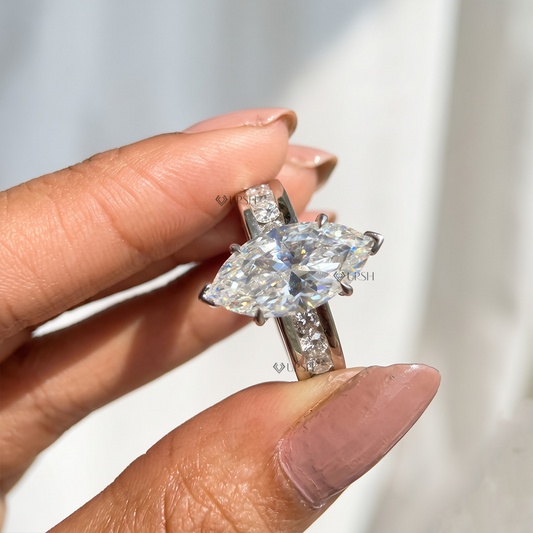 Holding white gold marquise diamond ring displaying substantial channel eternity shank