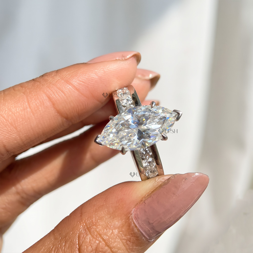 Holding white gold marquise diamond ring displaying substantial channel eternity shank