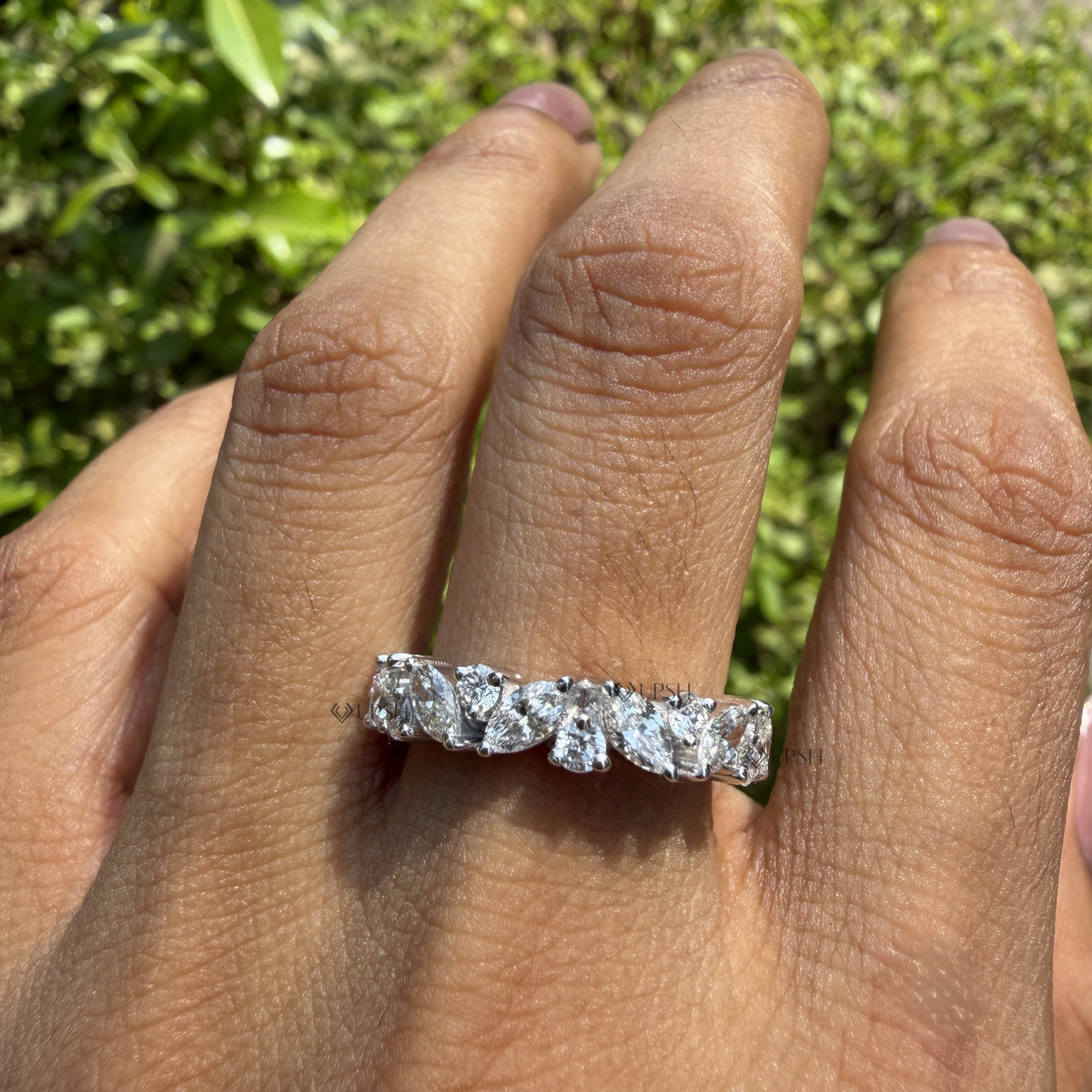Natural sunlight sparkle of white gold marquise and round diamond wedding band on hand
