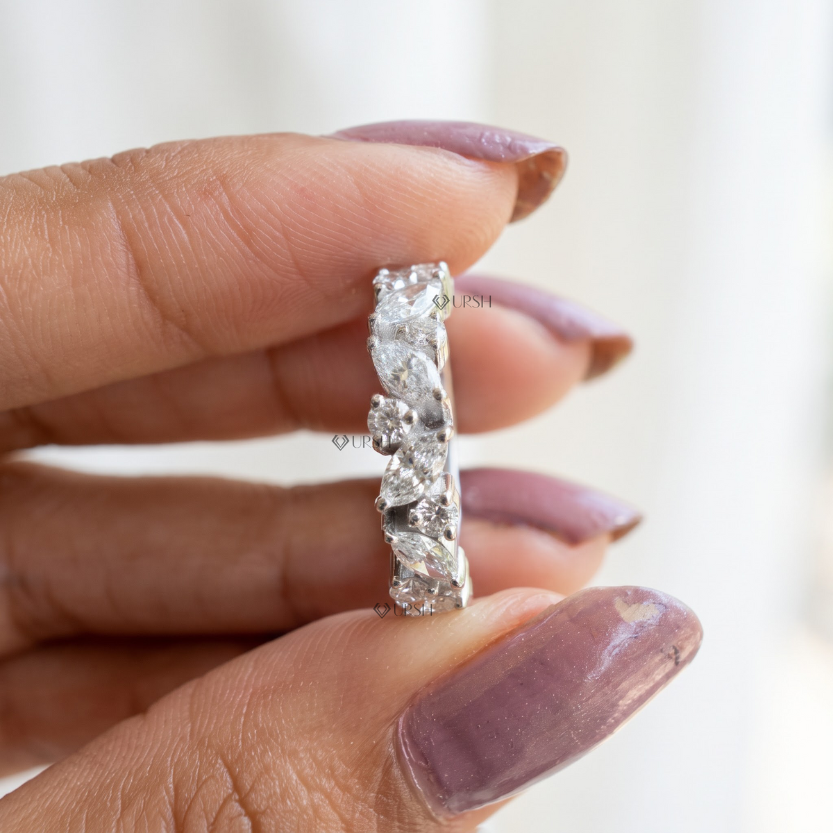 Close-up holding white gold alternating marquise and round lab diamond band showcasing prong setting