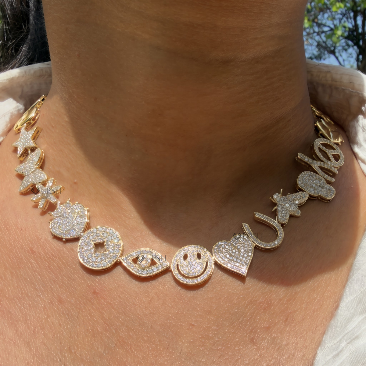 Yellow gold multi-charm eclectic diamond station necklace styled gracefully on neck in natural daylight