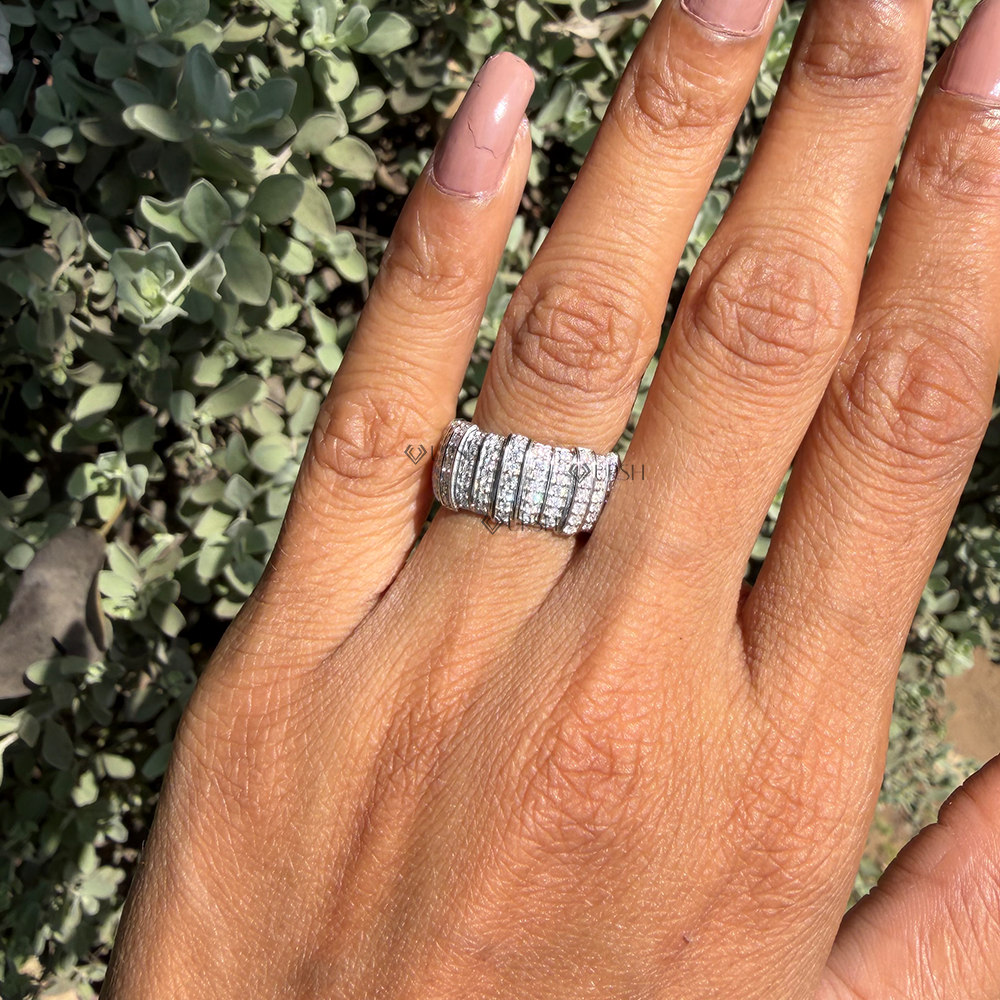 Detailed daylight macro close-up of vertical micro-pavé tracks and polished separator rails on wide barrel ring worn on finger