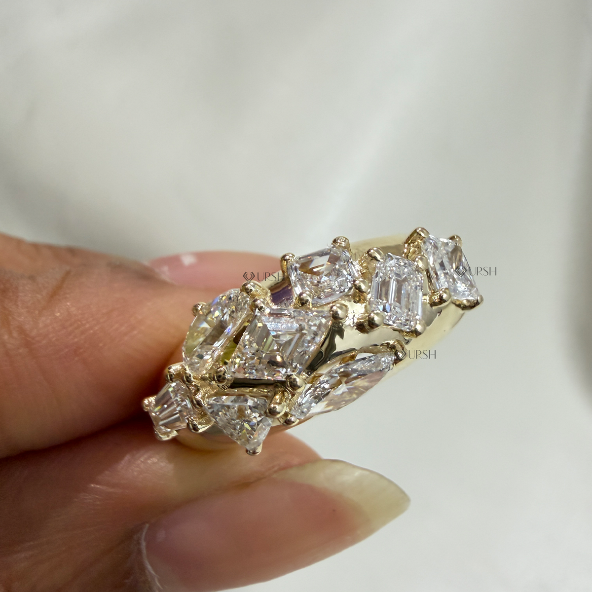Close-up holding chunky yellow gold multi-diamond mosaic band showing ring profile