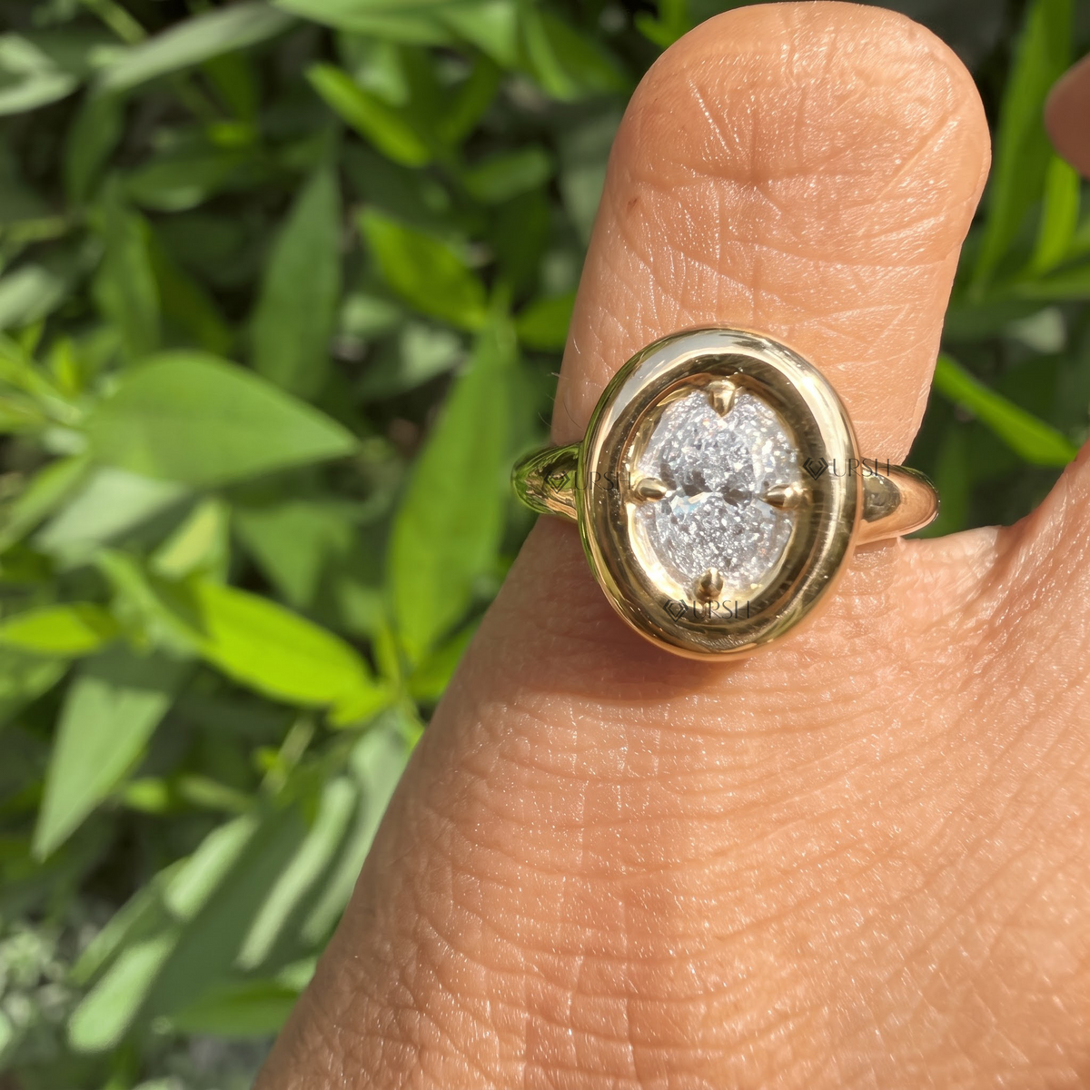 Oval halo bezel-set diamond statement ring styled gracefully on finger in natural daylight