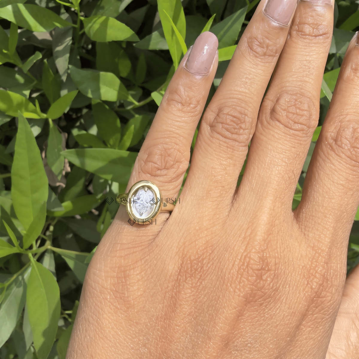 Detailed daylight macro close-up of oval-cut lab diamond in recessed bezel halo frame worn on finger
