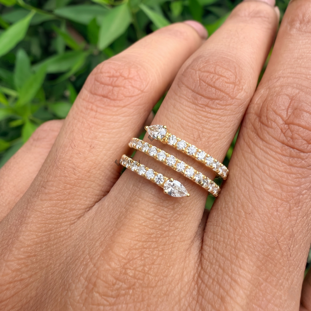 Coiled snake diamond wrap ring styled gracefully on finger in natural daylight