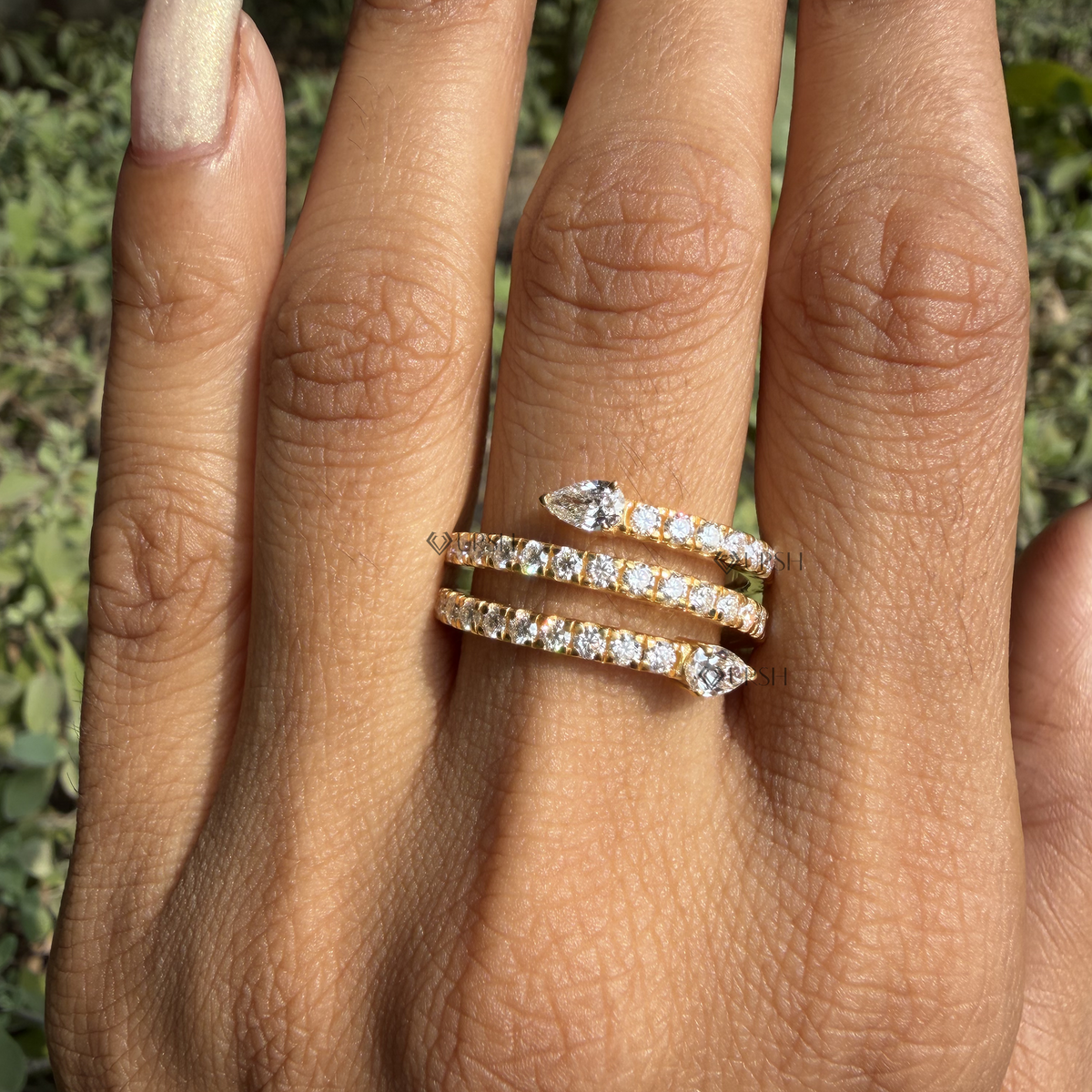 Wide daylight perspective of coiled snake ring worn against natural background foliage