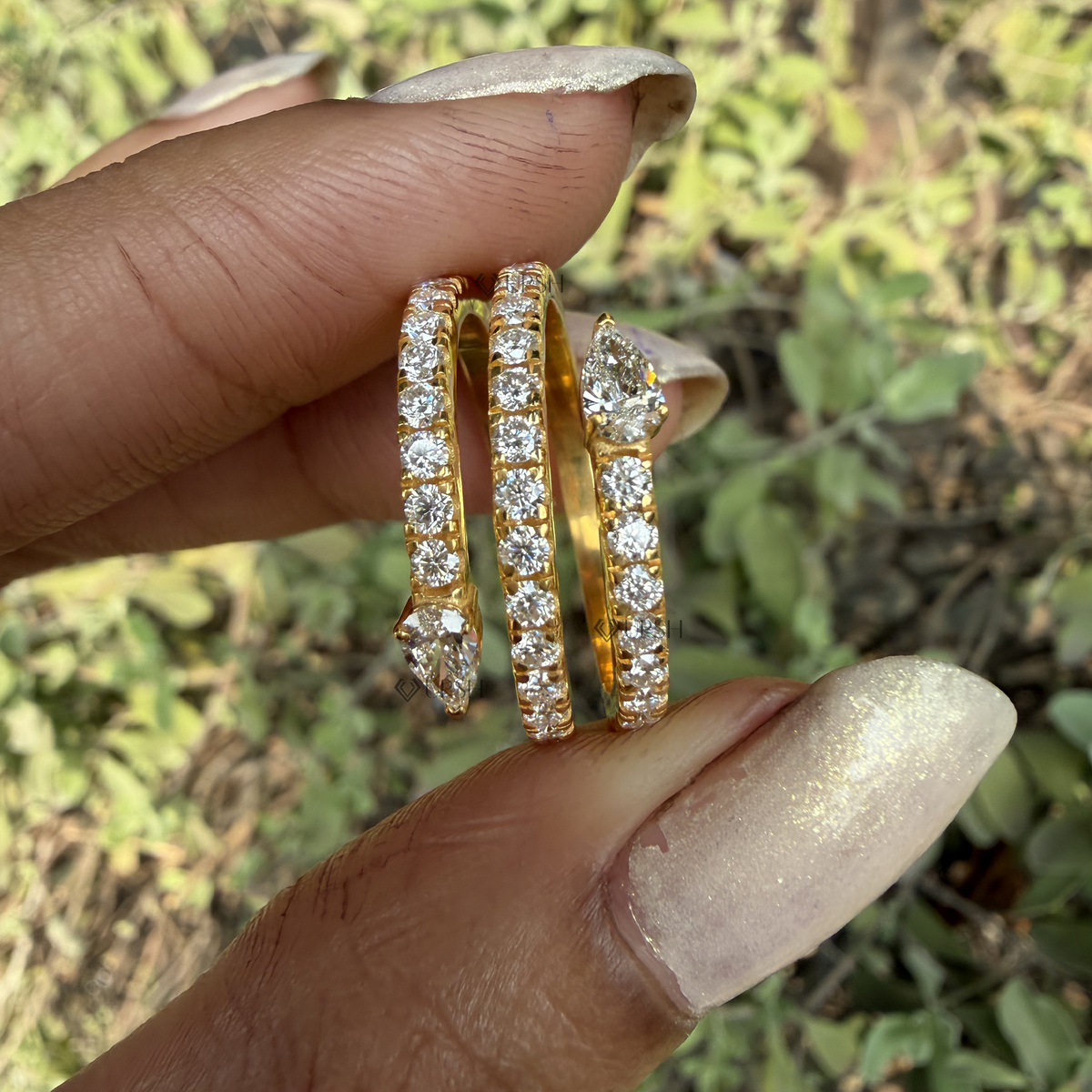 Detailed daylight macro close-up of multi-row pavé diamond snake ring showing pear-cut head detail worn on finger