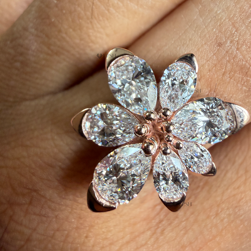Detailed daylight shot showing pear diamond facet fire and rose gold beaded pistil center