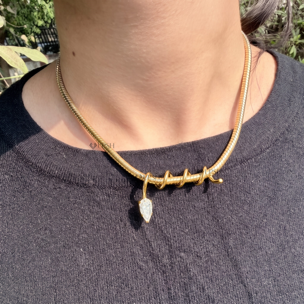 Daylight perspective of yellow gold pear diamond drop charm suspended from spiral wire collar chain