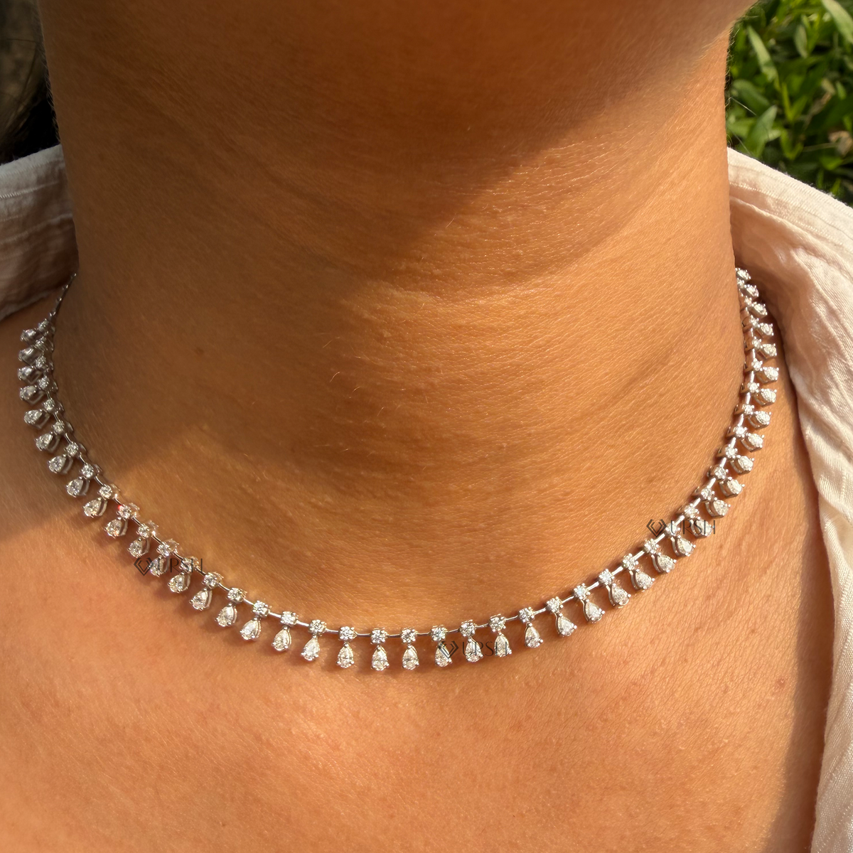 Yellow gold pear and round diamond dangle drop fringe chain necklace styled gracefully on neck in natural daylight