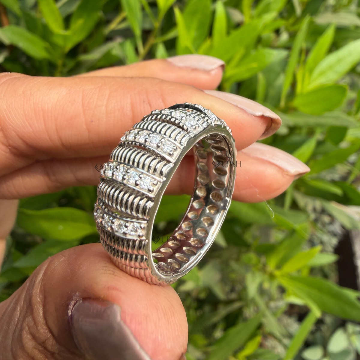 Daylight angle view of ribbed architectural band worn on finger highlighting bold texture