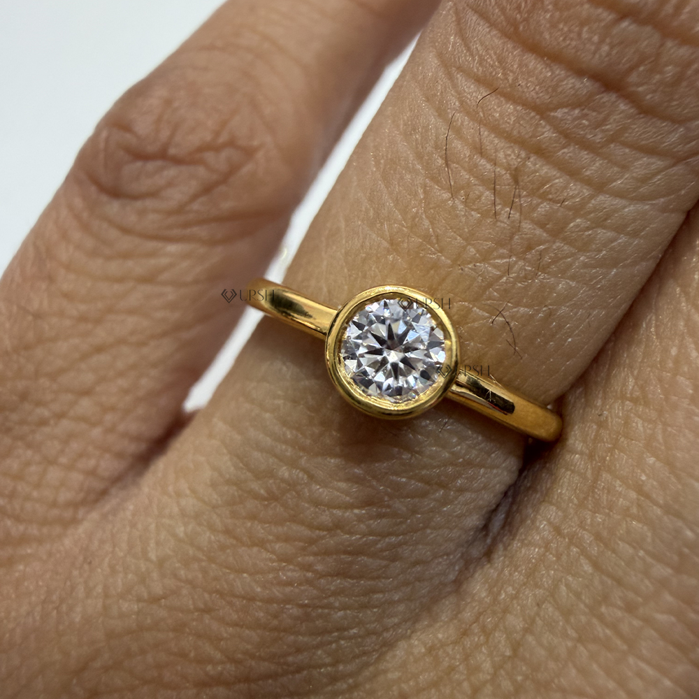 Detailed macro shot of brilliant round lab diamond encased in a polished solid yellow gold bezel frame