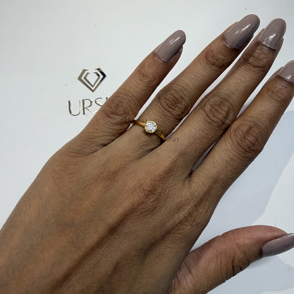 Subtle luxury and sleek shine of round diamond bezel ring on hand