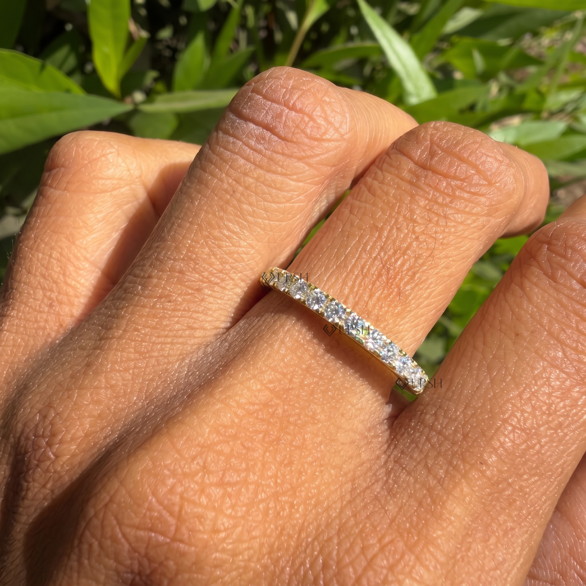 Full eternity diamond band styled gracefully on finger in natural daylight