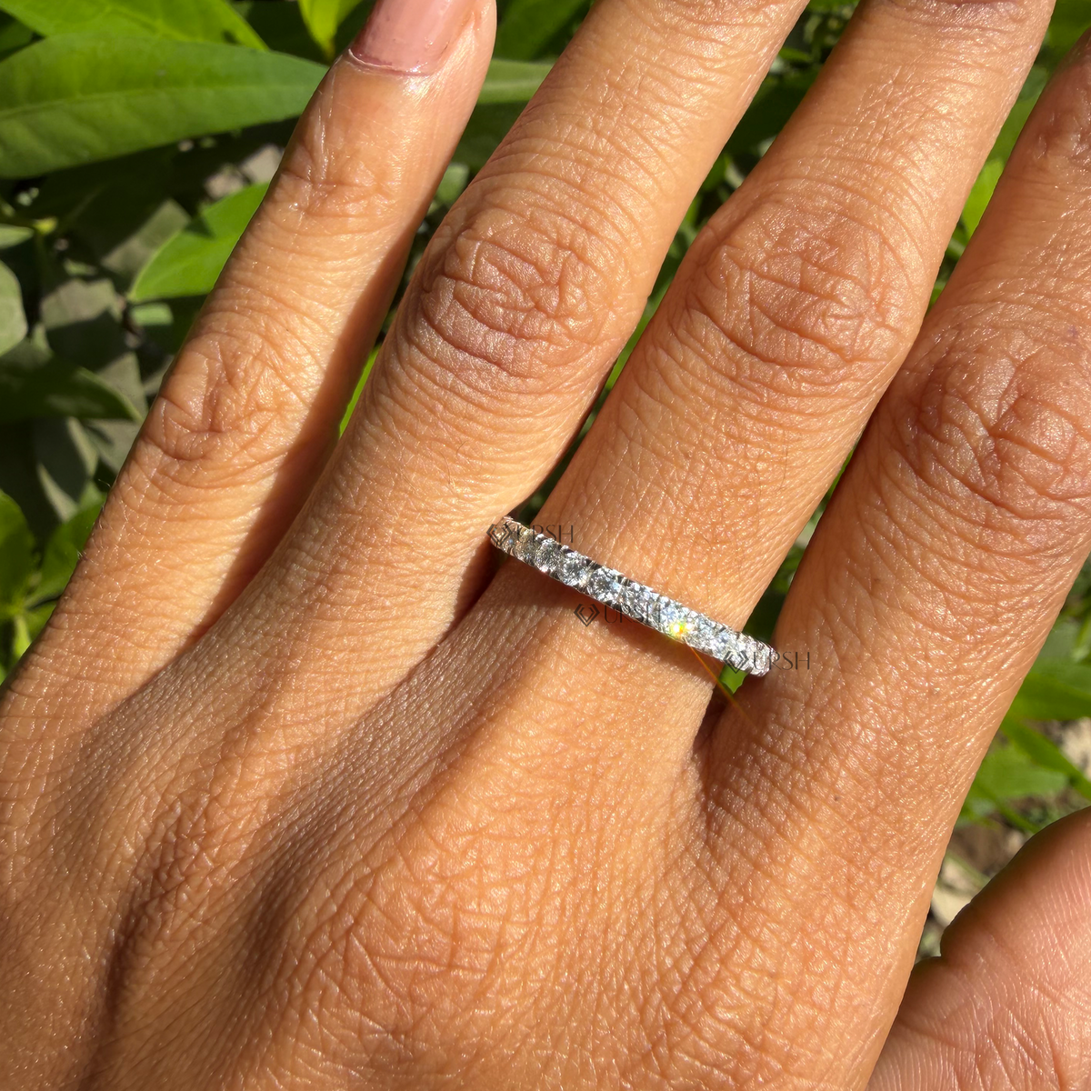 Daylight angle view of full eternity diamond band worn on hand showcasing continuous brilliance