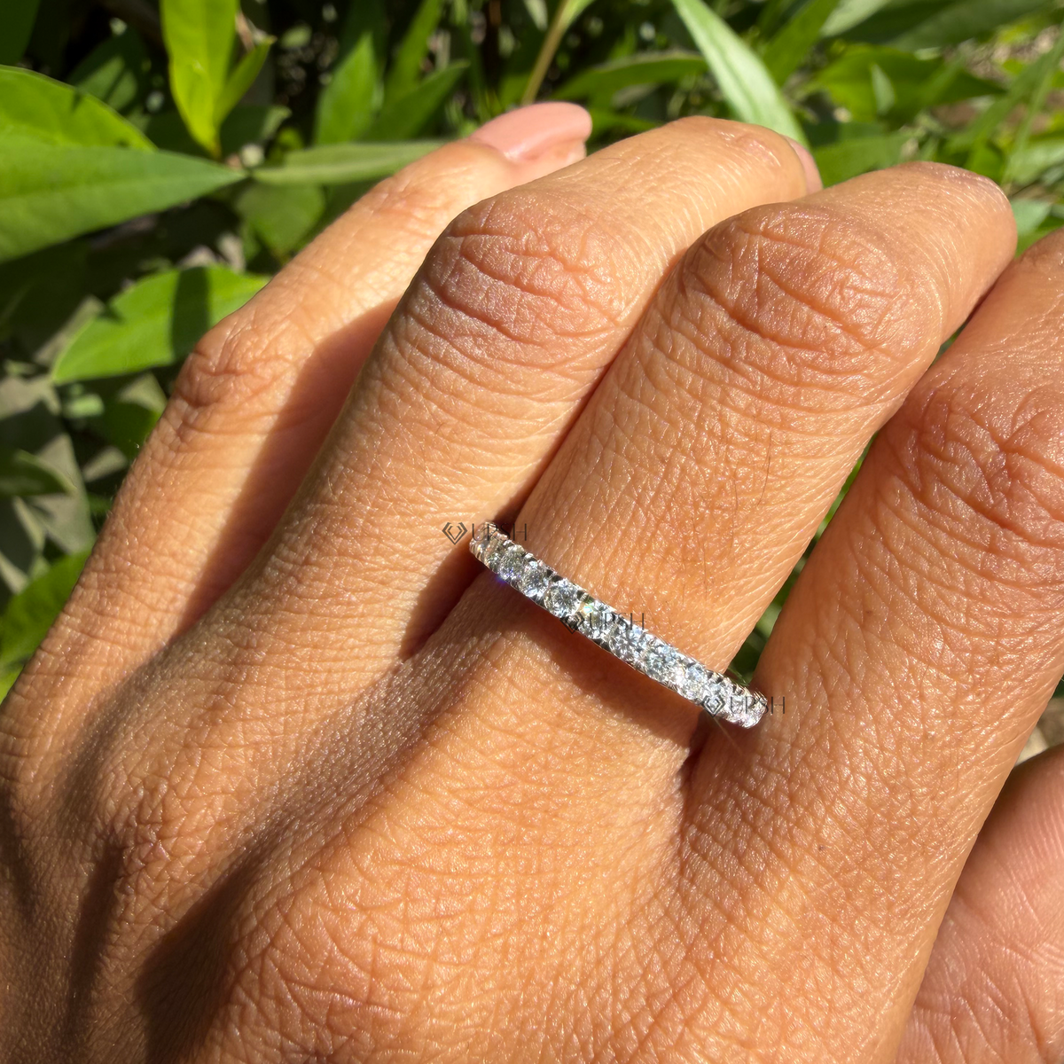 Daylight perspective of eternity ring worn against natural garden background