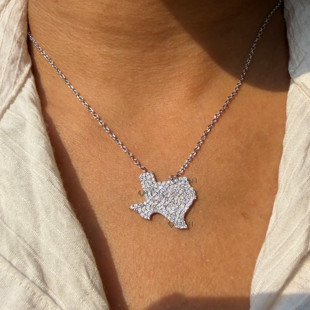 Daylight angle view of yellow gold Texas state map pavé diamond pendant chain worn on neck
