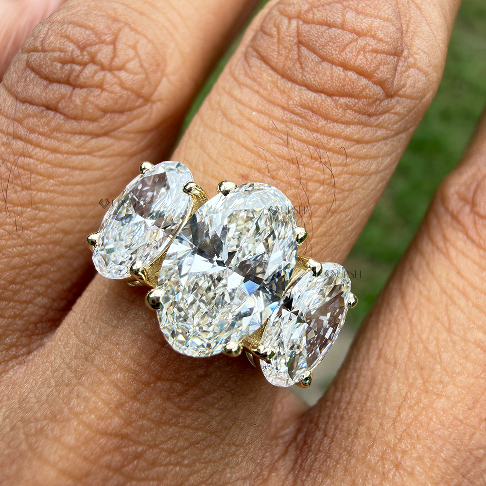 Yellow gold multi-stone oval diamond ring catching bright daylight on ring finger
