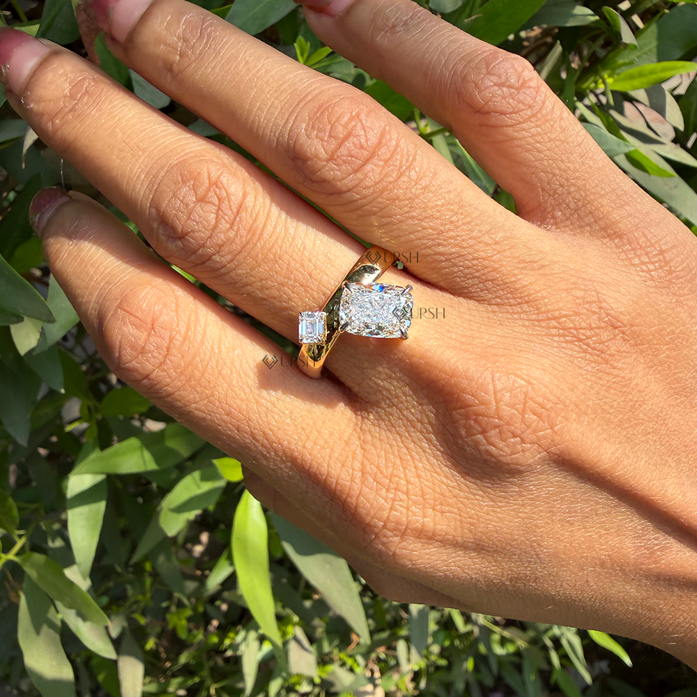 Two stone elongated cushion and emerald cut lab diamond bypass ring worn on hand outdoors