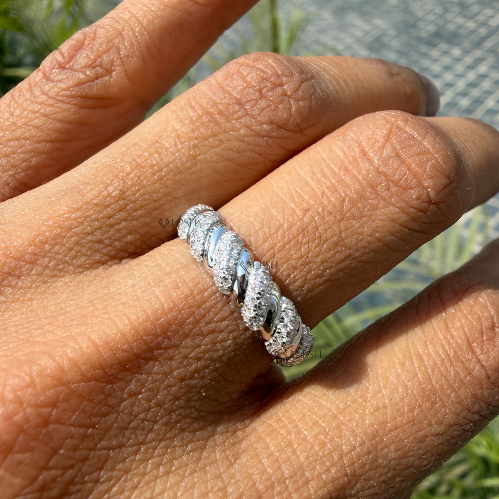 Spiraled diamond croissant ring worn on hand showcasing elegant texture in daylight