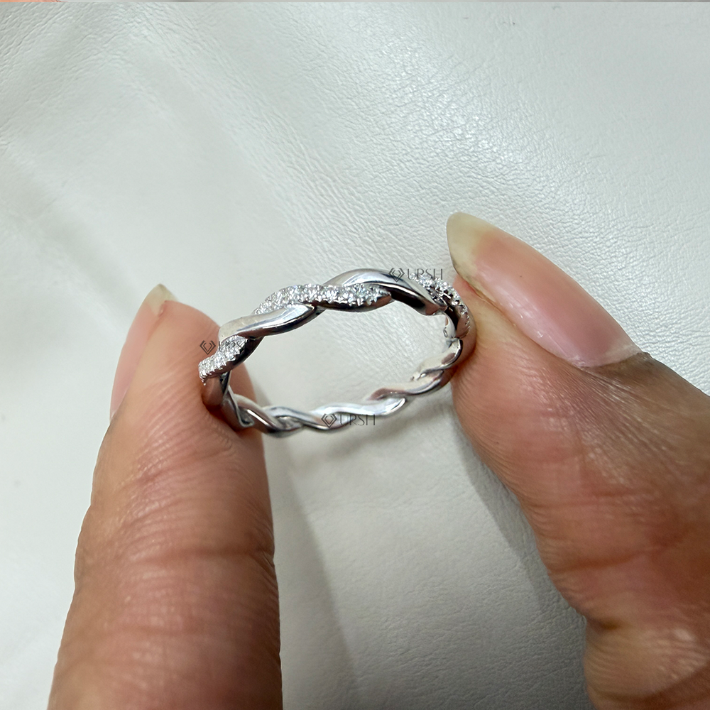 Detailed macro close-up holding white gold twisted rope band to display intertwined strands