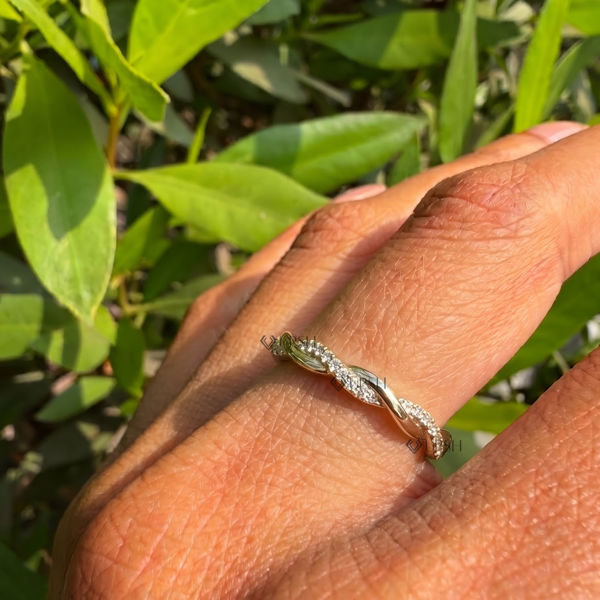 Daylight angle view of twisted rope pavé ring worn on finger showcasing delicate stackable profile