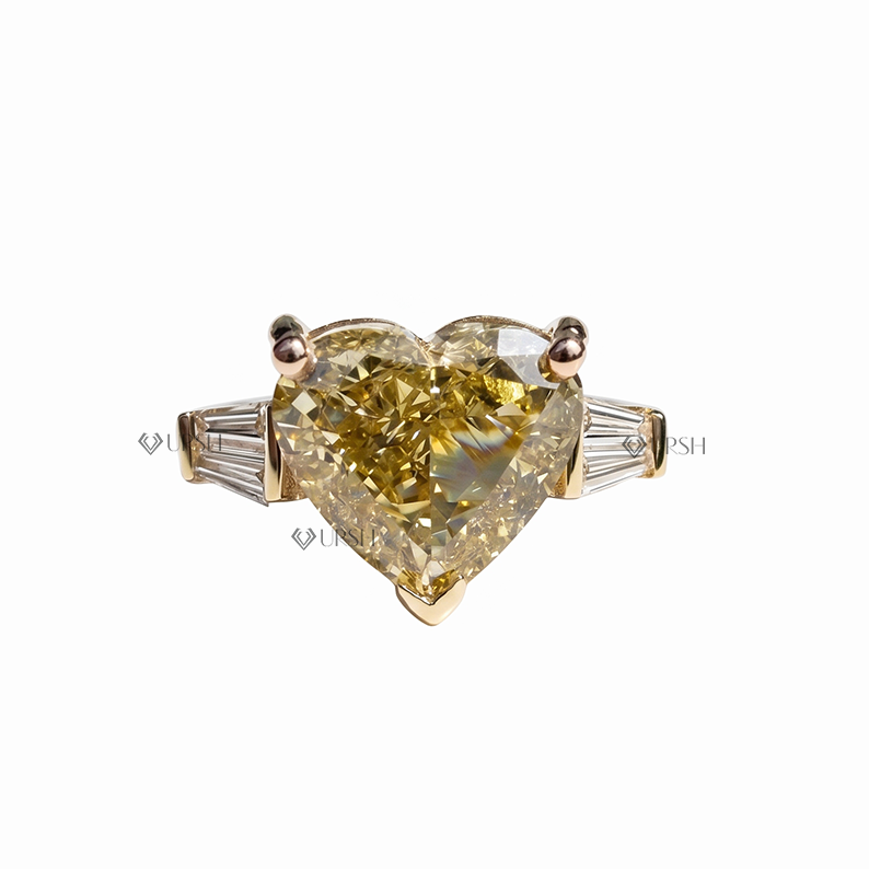 Solid two-tone gold three-stone engagement ring featuring fancy yellow heart cut lab diamond with tapered baguette side stones