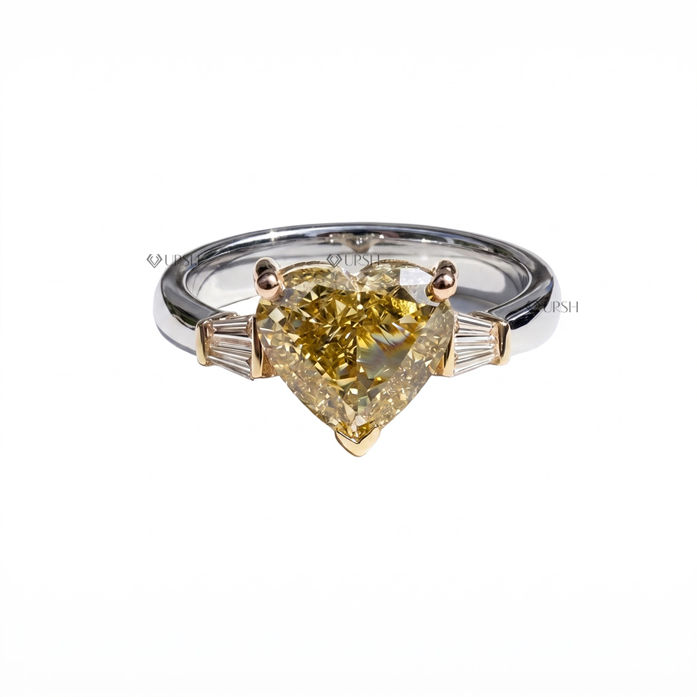 White gold three-stone ring with yellow gold prongs securing fancy yellow heart diamond and side baguettes
