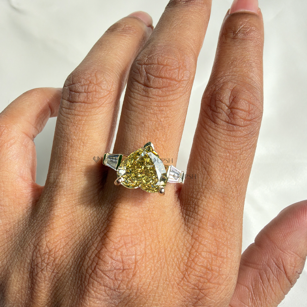 Heart cut yellow diamond ring styled on ring finger showcasing finger coverage and contrast