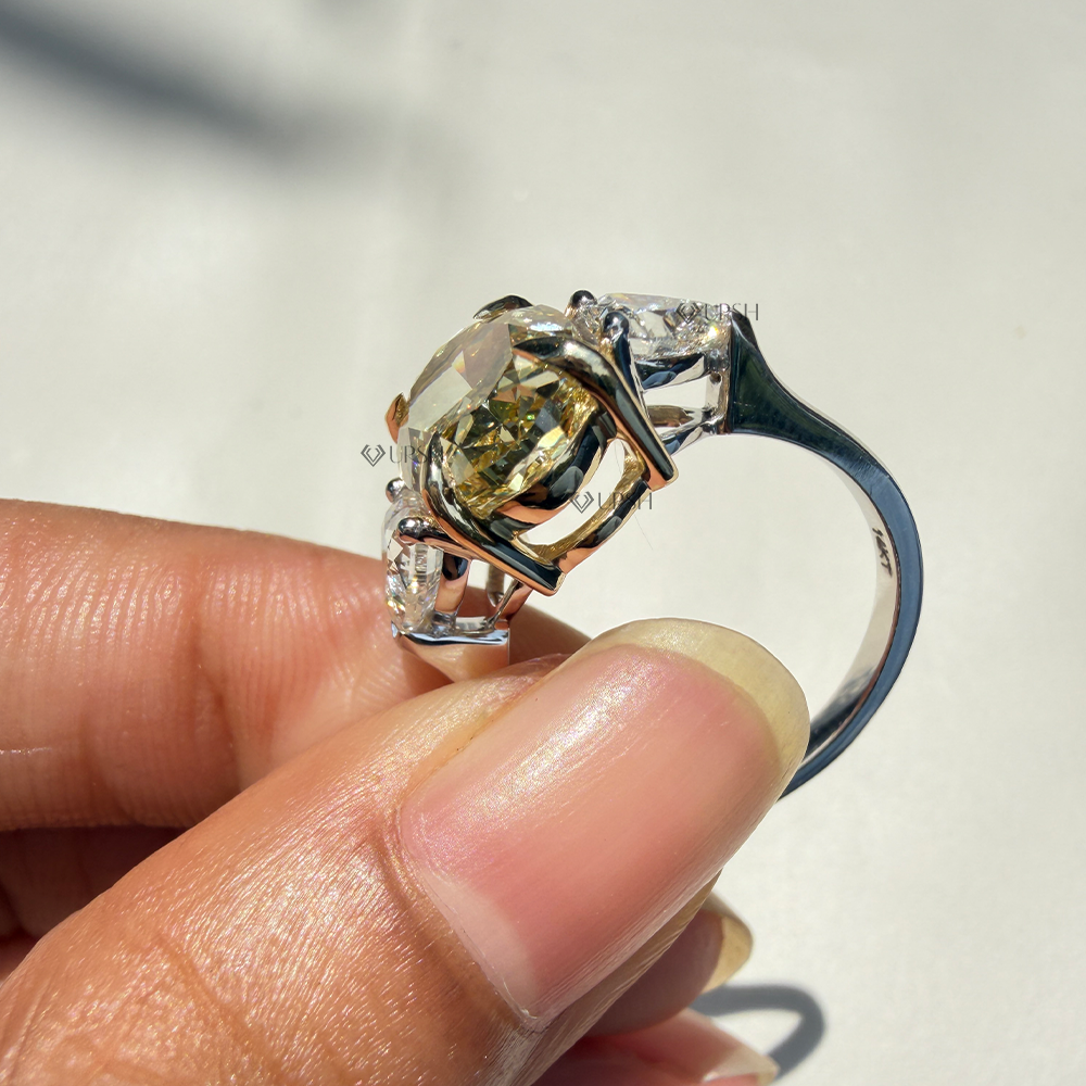 Side profile view highlighting yellow gold center basket and white gold shank arch