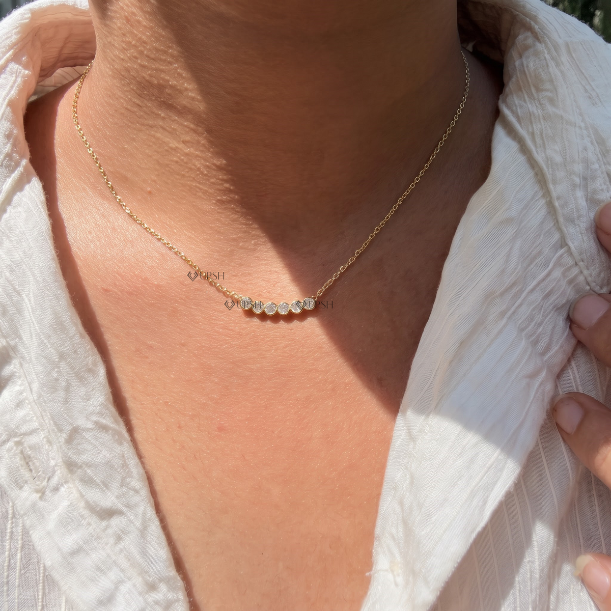 Yellow gold curved bezel diamond bar smile pendant necklace styled gracefully on neck in natural daylight