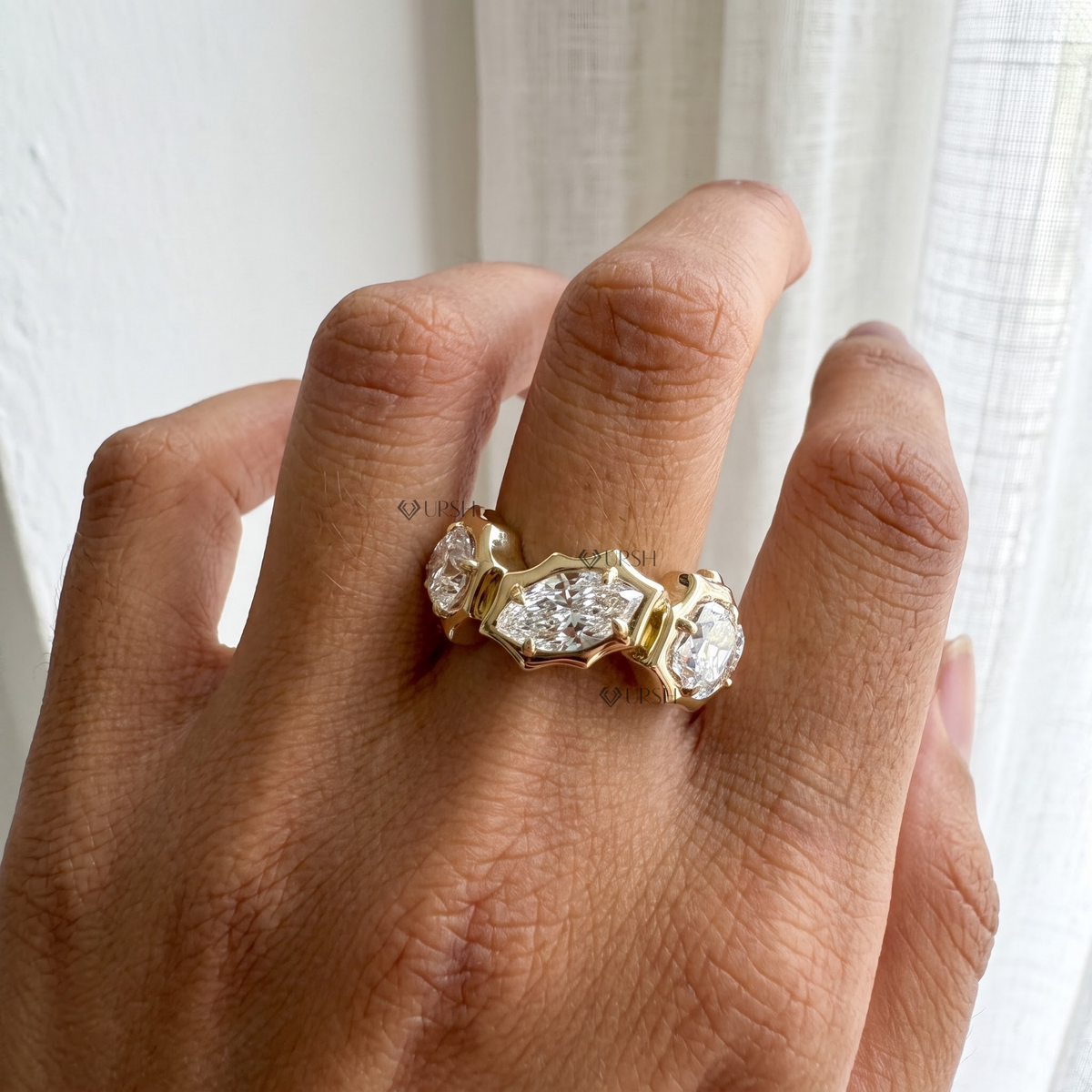 Top-down finger perspective highlighting mixed pear and round brilliant lab diamonds in solid gold frame
