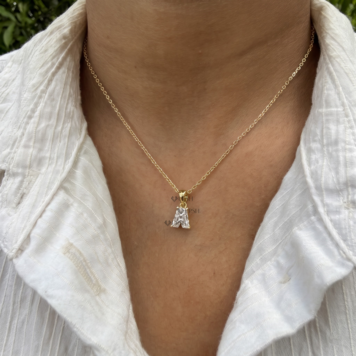 White gold letter A custom diamond initial pendant necklace styled gracefully on neck in natural daylight