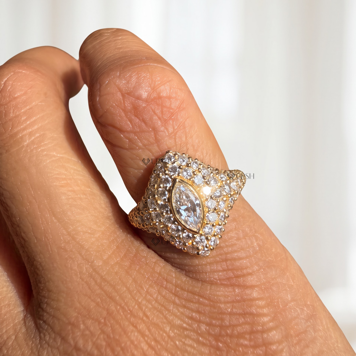 Solid yellow gold marquise diamond pave signet ring worn on woman's pinky finger.